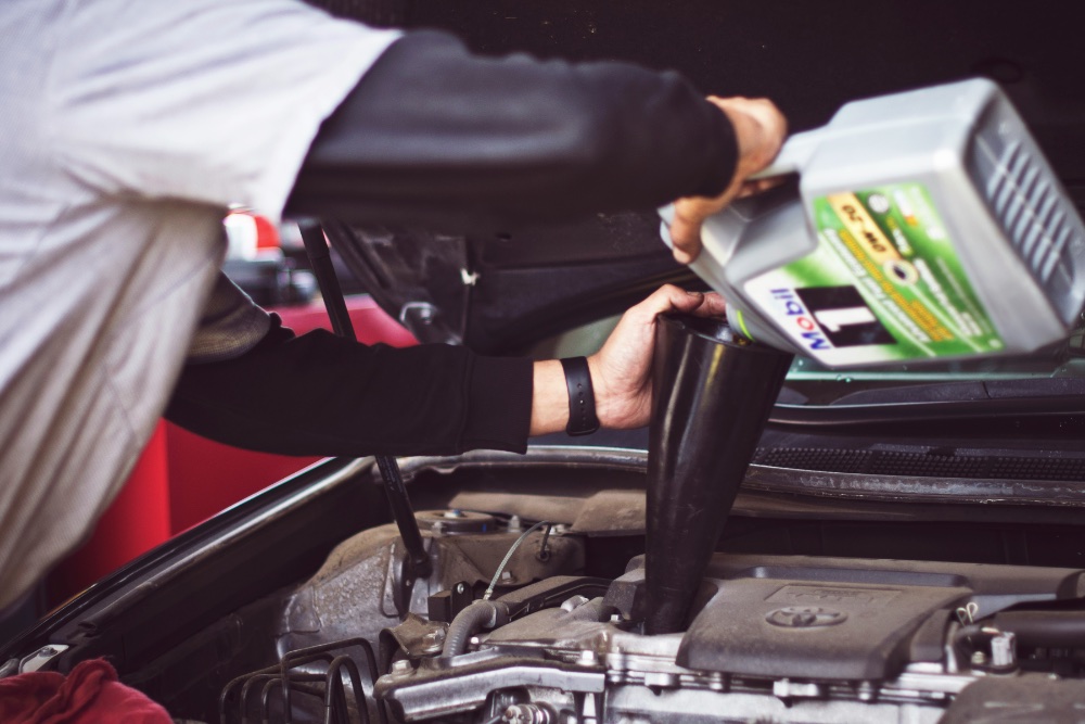 Mechanic pouring oil into engine